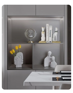 Detail of white ceramic Egyptian cat bookends and abstract vases in a modern shelf