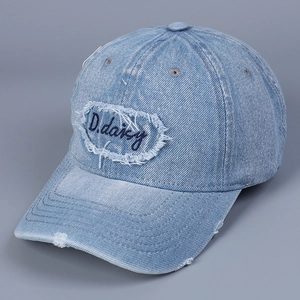 Dettaglio cappello da baseball in denim con ricamo D.daisy e toppa con effetto usurato