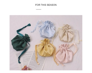Flat lay of colorful satin drawstring pouches for eye masks and cosmetic storage