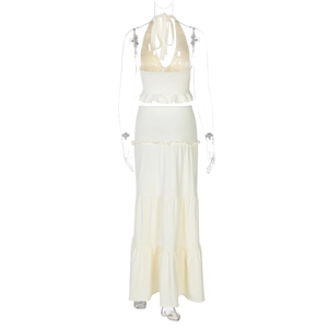 Detailed view of white two-piece set featuring halter neck top and tiered maxi skirt