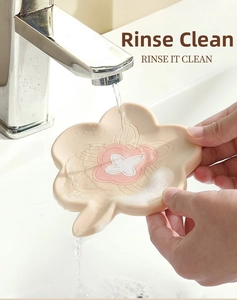 Detail of flower-shaped silicone soap dish being rinsed under running water on a sink
