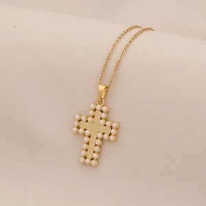 Detailed view of golden cross pendant featuring white pearl borders on thin gold O-chain