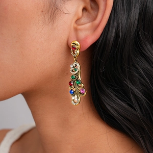 Gros plan de boucles d'oreilles vintage dorées avec strass colorés sur un modèle