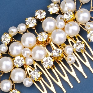 Exquisite bridal hair comb with pearls and rhinestones on gold base, close-up view