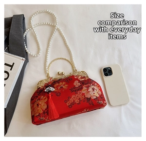 Détail de broderie florale sur sac vintage avec poignée en perles et pompon rouge