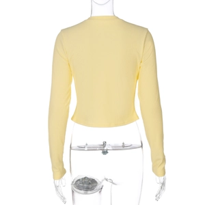Détail de la texture en maille côtelée jaune et manches longues au dos du haut moulant