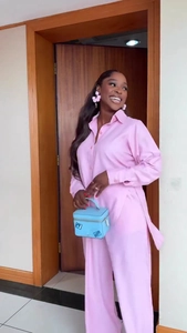 Detail of pink long-sleeve shirt and wide-leg trousers set with light glossy fabric