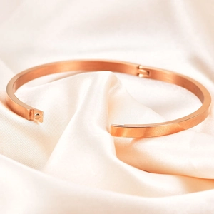 Minimalist 4mm rose gold open cuff bracelet on elegant beige silk background