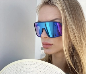 Close-up of blue cycling sunglasses with large mirrored lens on a model for outdoor sports