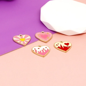 Macro detail of heart-shaped enamel charms with colorful stripes and patterns