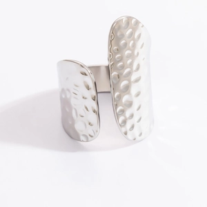 Macro shot of a minimalist silver stainless steel cuff bracelet with hammered texture