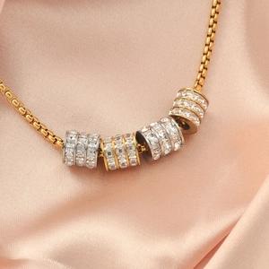 Golden chain necklace with five hollow cylindrical spacer beads set with sparkling crystals