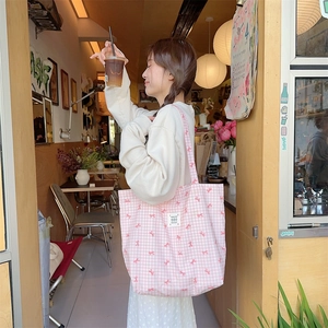 Detailed view of pink plaid canvas tote bag featuring cute bow prints and spacious design