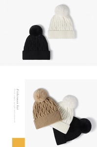 Detail of three knitted hats with fluffy fur pom poms and thick textured weave patterns