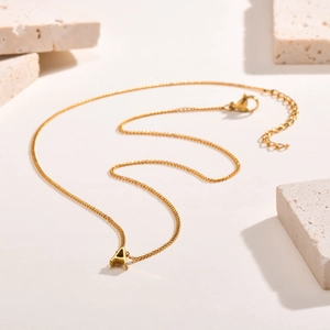Gold plated stainless steel necklace featuring letter A pendant on a textured stone