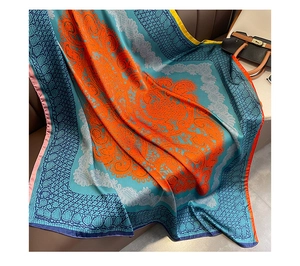 Détail d'un foulard en soie aux motifs floraux classiques et bordure en dentelle paisley