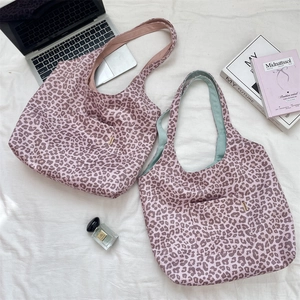 Close-up of leopard print suede tote bags with contrasting pink and mint green lining