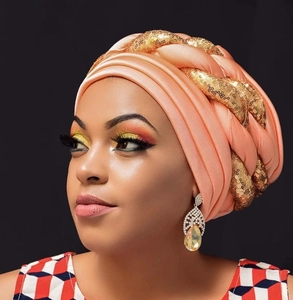 Detail of peach pink sequined turban with golden accents and matching teardrop earrings