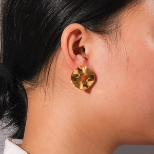 Close-up of model wearing 18K gold plated irregular wavy round stainless steel earrings