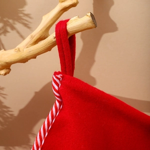 Close-up of red Christmas stocking with red and white striped edge and hanging loop