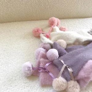 Winter plush leg warmers with satin bows and fluffy pom poms in soft pastel colors