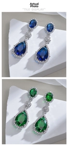 Macro detail of tear-drop earrings featuring blue and emerald green cubic zirconia gems