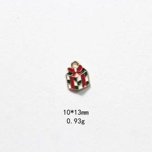 Detail of red and green enamel gift box pendant with gold metal edges for DIY jewelry