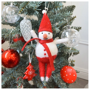 Detailed view of a handmade wool felt snowman hanging on a festive Christmas tree branch