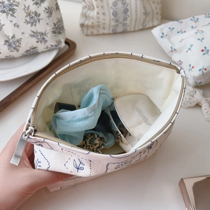 Macro detail of floral canvas makeup bag with silver zipper and blue pattern print