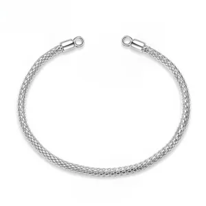 Detail of silver mesh braided open bangle with rounded end caps in minimalist style