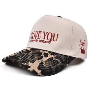 Close-up of I Love You embroidery and cherry bow detail on leopard print baseball cap