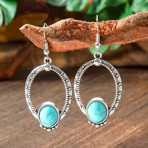 Detailed macro view of bohemian drop earrings with turquoise stone and vintage silver finish