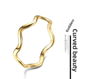 Detailed close-up of a polished gold titanium steel wavy band ring for women