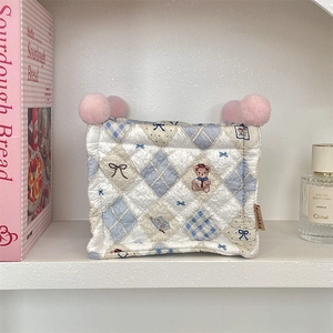 Close-up of quilted storage basket with blue diamond pattern and cartoon bear prints