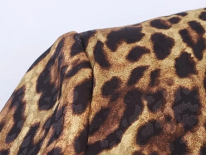 Detalle de la textura del tejido de leopardo y costuras en un traje de mujer
