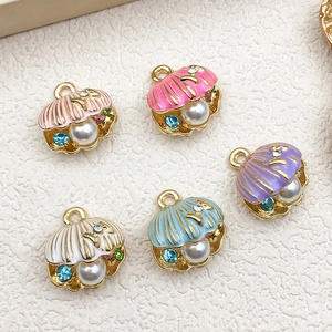 Macro detail of enamel seashell charms with pearls and rhinestones for DIY jewelry
