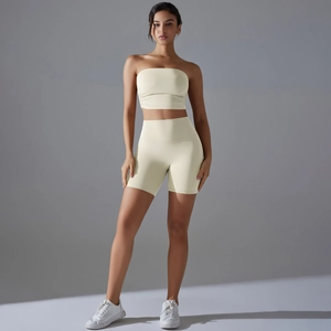 Two-piece yoga set featuring a cream yellow strapless top and high-waisted fitness shorts