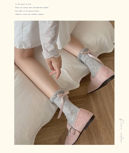 Dettagli di calze grigie in maglia con fiocchi rosa e scarpe Mary Jane in velluto rosa