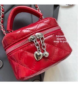 Detailed macro view of red quilted leather mini box bag with heart zipper pullers