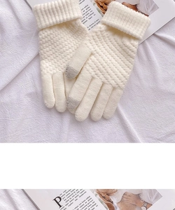 Dettaglio di guanti touch in maglia crema con punta delle dita grigia e polsini a coste