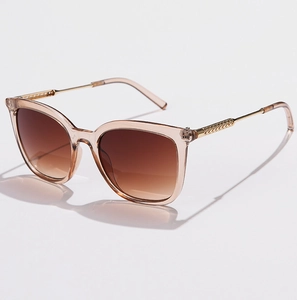 Detail of gradient brown lenses and ornate gold hollow metal temples on champagne sunglasses