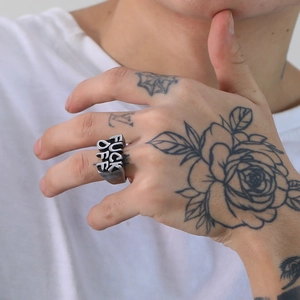 Close-up of vintage punk steel ring with embossed FUCK OFF lettering on male hand