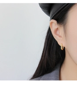Primo piano di eleganti orecchini a cerchio ovali in argento S925 placcati in oro