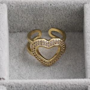 Macro di un anello aperto dorato con cuore decorato con micro-pave di zirconi
