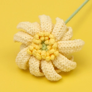 Nahaufnahme einer handgehäkelten Gerbera-Blume mit detaillierter beigefarbener Garnstruktur