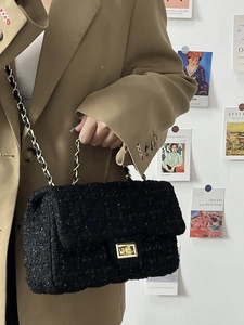Detail of tweed crossbody bag with gold chain strap worn with a khaki blazer