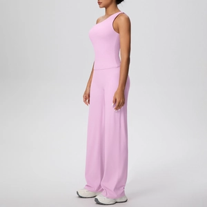 Détail du haut de yoga rose à une épaule et du pantalon large de sport