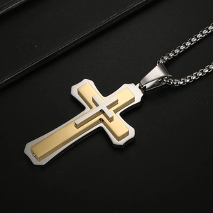 Détail d'un pendentif croix double couche en acier inoxydable bicolore or et argent