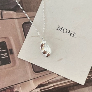 Macro detail of irregular silver liquid teardrop pendant on minimalist chain with mirror finish