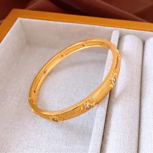 24K gold plated vintage bangle with sunburst pattern and clear crystals on a brushed finish
